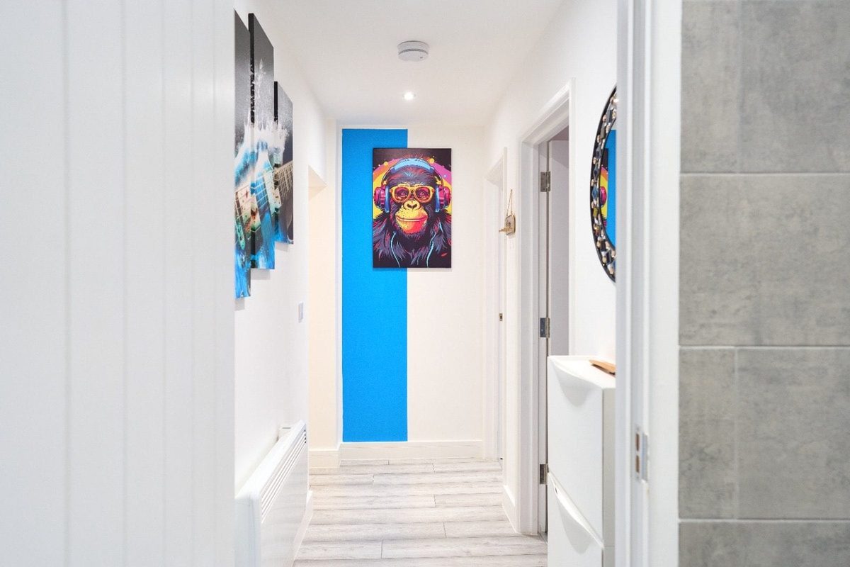 Bright hallway with a blue stripe and a framed ape print