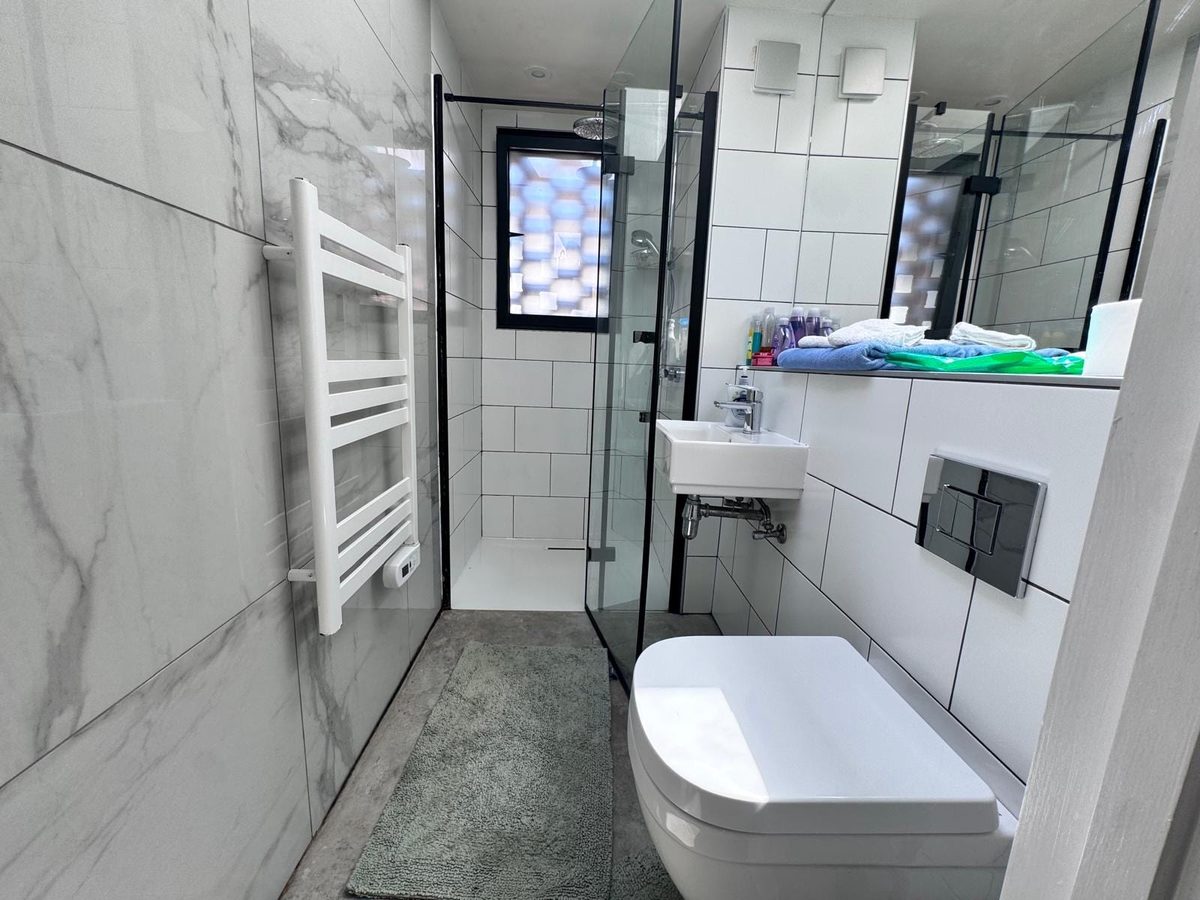 Marble-tiled shower room with a walk-in glass enclosure